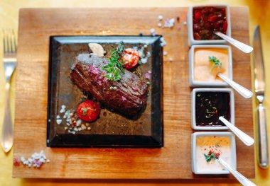 Restoran yemeği. Taze sebzeli ızgara domuz eti. Bitki ve baharatlı madalyonlar..