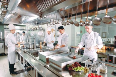 Modern mutfak. Aşçılar restoranın ya da otelin mutfağındaki ocakta yemek hazırlarlar. Mutfaktaki yangın.