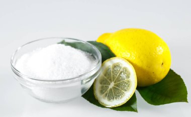 Beyaz arka planda limon asidi ve limon meyvesi.