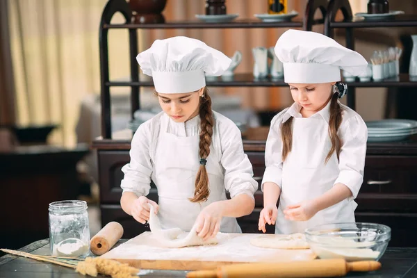 Chicas divertidas niños están preparando la masa en la cocina. — Foto de Stock