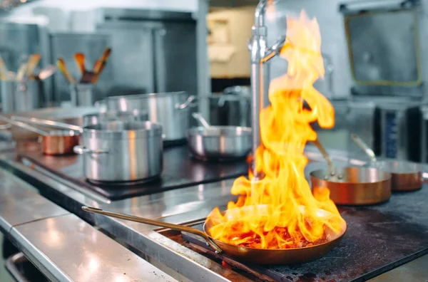 Cocina moderna. Los cocineros preparan comidas en la estufa en la cocina del restaurante u hotel. El fuego en la cocina. — Foto de Stock