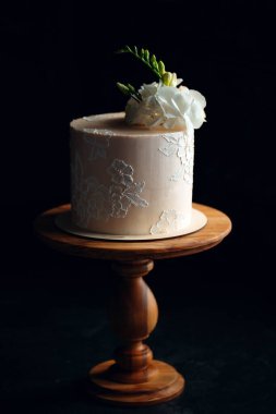 Kek koyu arkaplanda çiçeklerle süslenir..