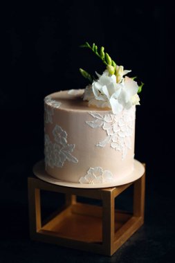 Kek koyu arkaplanda çiçeklerle süslenir..