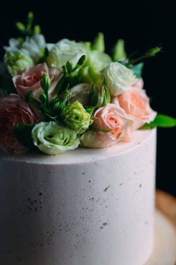 Kek koyu arkaplanda çiçeklerle süslenir..