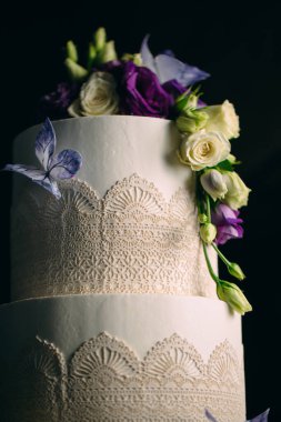 Kek koyu arkaplanda çiçeklerle süslenir..