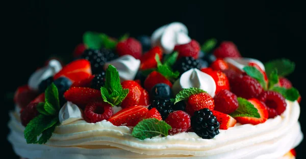 Bolo de frutas. Bolo decorado com bagas em um suporte de madeira em um fundo preto. — Fotografia de Stock