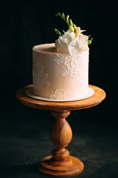 Η τούρτα είναι διακοσμημένη με λουλούδια σε σκούρο φόντο. — Φωτογραφία Αρχείου