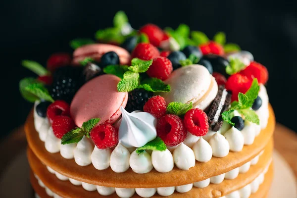 Bolo de frutas. Bolo decorado com bagas em um suporte de madeira em um fundo preto. — Fotografia de Stock