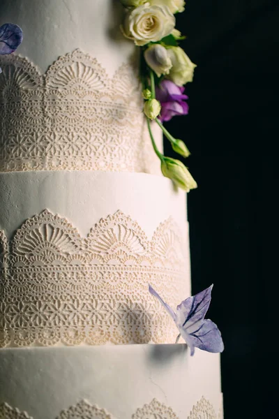 La torta è decorata con fiori su uno sfondo scuro. — Foto Stock