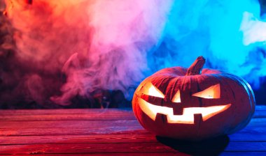 Gecenin karanlığında bir ormanda Ağaçta Cadılar Bayramı Balkabağı.