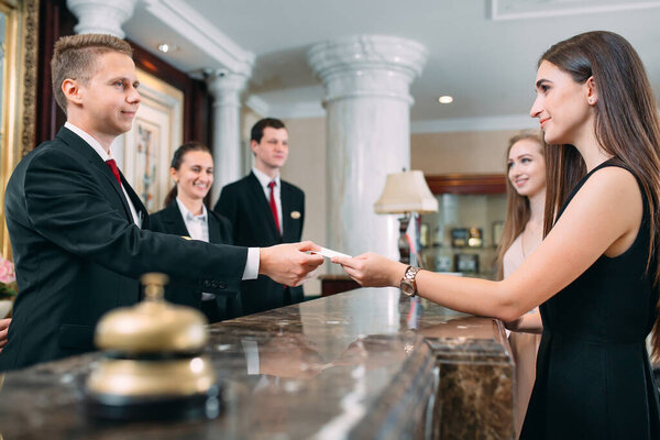 Picture of guests getting key card in hotel.