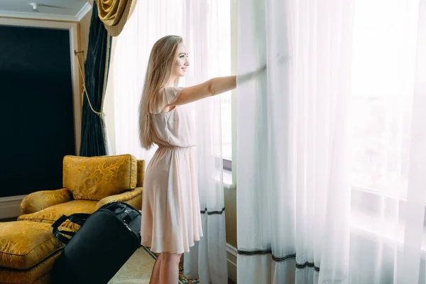 Mujeres jóvenes con maleta se alojan en una habitación de hotel. —  Fotos de Stock