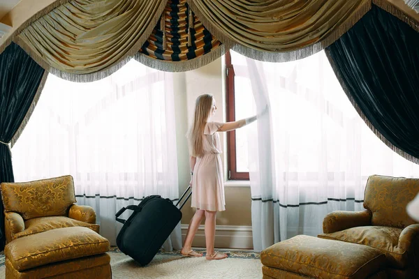 Mujeres jóvenes con maleta se alojan en una habitación de hotel. —  Fotos de Stock