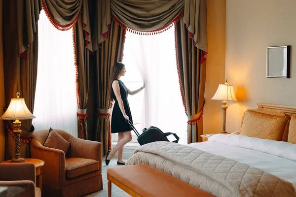 提着手提箱的年轻妇女住在旅馆房间里. — 图库照片