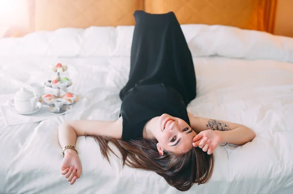 Gadis itu berbaring di tempat tidur di kamar hotel atau di rumah. — Stok Foto