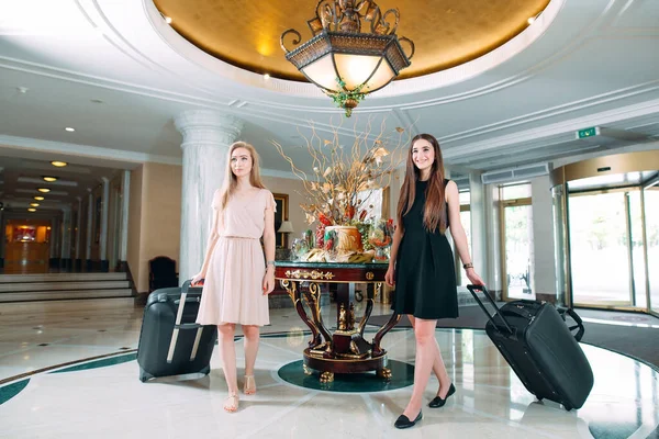 Giovani ragazze vicino alla reception in hotel. Giovani ragazze viene in hotel. — Foto Stock