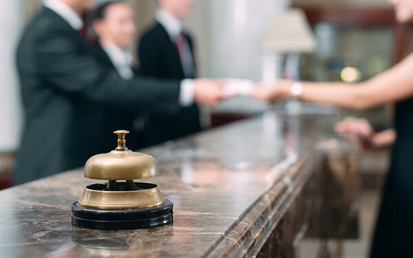 Picture of guests getting key card in hotel.