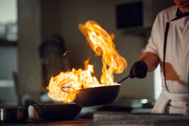 Modern mutfak. Aşçılar restoranın ya da otelin mutfağındaki ocakta yemek hazırlarlar. Mutfaktaki yangın..