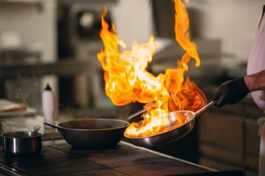 Modern mutfak. Aşçılar restoranın ya da otelin mutfağındaki ocakta yemek hazırlarlar. Mutfaktaki yangın..
