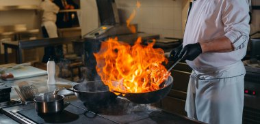 Modern mutfak. Aşçılar restoranın ya da otelin mutfağındaki ocakta yemek hazırlarlar. Mutfaktaki yangın..