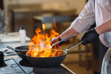 Modern mutfak. Aşçılar restoranın ya da otelin mutfağındaki ocakta yemek hazırlarlar. Mutfaktaki yangın..