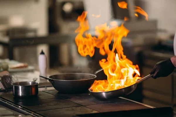 Cocina moderna. Los cocineros preparan comidas en la estufa en la cocina del restaurante u hotel. El fuego en la cocina. — Foto de Stock