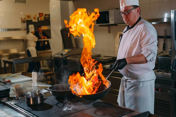 Cocina moderna. Los cocineros preparan comidas en la estufa en la cocina del restaurante u hotel. El fuego en la cocina. — Foto de Stock