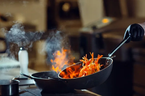 Cocina moderna. Los cocineros preparan comidas en la estufa en la cocina del restaurante u hotel. El fuego en la cocina. — Foto de Stock