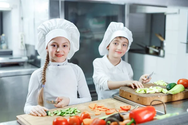 Kinder mahlen Gemüse in der Küche eines Restaurants. — Stockfoto