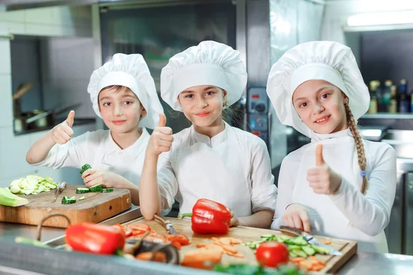 Los niños muelen verduras en la cocina de un restaurante. — Foto de Stock