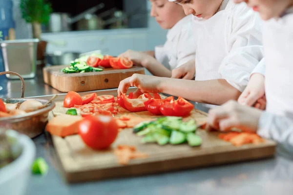 Los niños muelen verduras en la cocina de un restaurante. —  Fotos de Stock