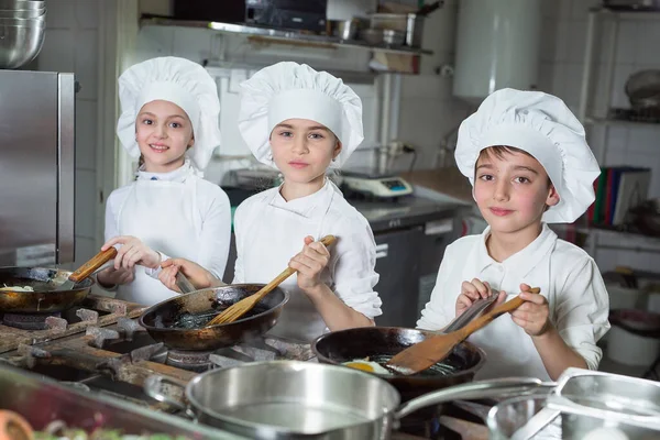 Crianças cozinham ovos na cozinha do Restaurante. — Fotografia de Stock