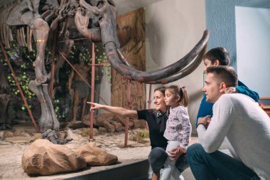 Müzedeki aile. Paleontoloji Müzesi 'nde bir aile bir mamut iskeletinin önünde duruyor..