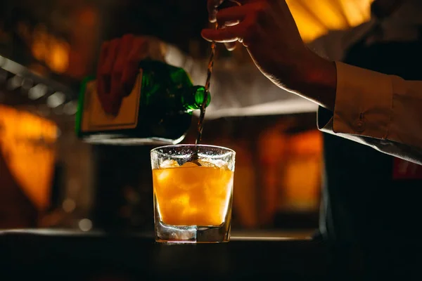 Bartendern förbereder en cocktail i baren. Bartendern häller alkohol från en flaska. — Stockfoto