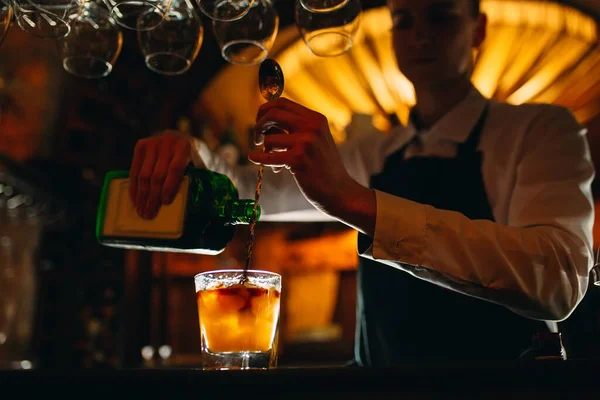 El camarero prepara un cóctel en el bar. El camarero vierte alcohol de una botella. — Foto de Stock