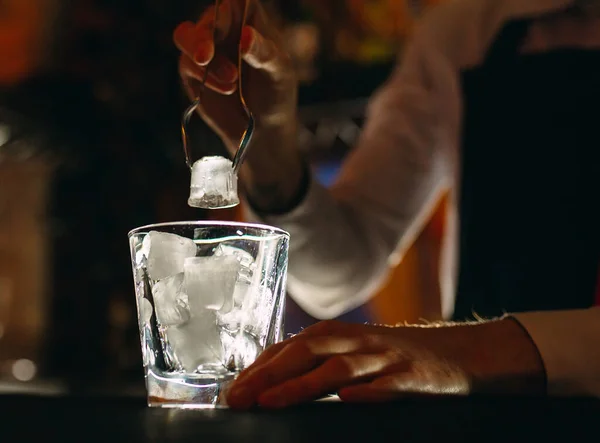 El camarero vierte hielo en vasos de cóctel. — Foto de Stock