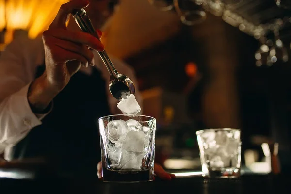 El camarero vierte hielo en vasos de cóctel. — Foto de Stock