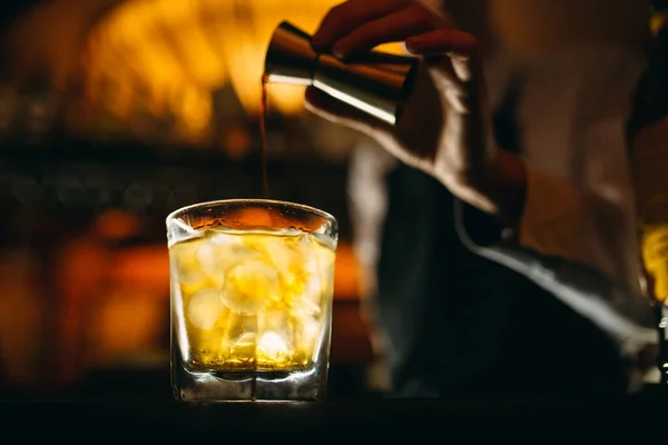 Bartendern häller whisky på baren.. — Stockfoto