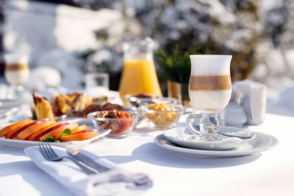 Café con leche en la terraza frente al restaurante contra la nieve. — Foto de Stock