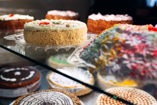 Cukrászda üveg kijelző válogatott tejszín vagy gyümölcs torta. — Stock Fotó