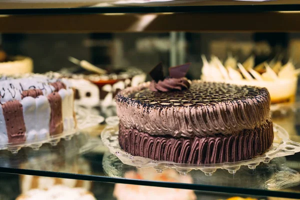 Gebak glazen display met selectie van room of fruit cake. — Stockfoto