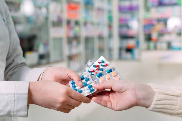 Primer plano de una chica manos comprando pastillas en una farmacia. — Foto de Stock