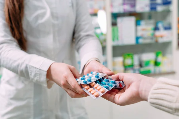 Primer plano de una chica manos comprando pastillas en una farmacia. — Foto de Stock