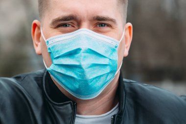 Tıbbi maskeli Avrupalı bir adamın portresi.