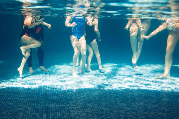 Undervattensfoto av unga vänner i poolen. — Stockfoto
