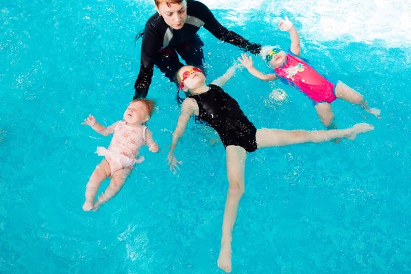 Ein Schwimmlehrer bringt einem Kind das Schwimmen im Pool bei. — Stockfoto