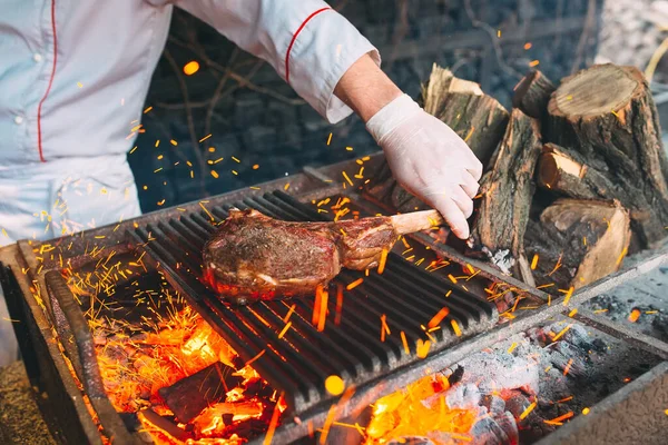 Chef Cooking steak. Cozinheiro vira a carne no fogo. — Fotografia de Stock