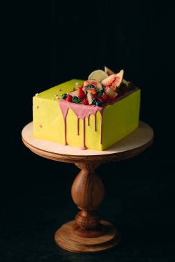 İncir, ahududu, yabanmersini ve limonla süslenmiş sarı turunçgil keki..