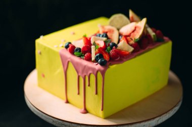 İncir, ahududu, yabanmersini ve limonla süslenmiş sarı turunçgil keki..