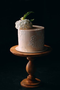 Kek koyu arkaplanda çiçeklerle süslenir..